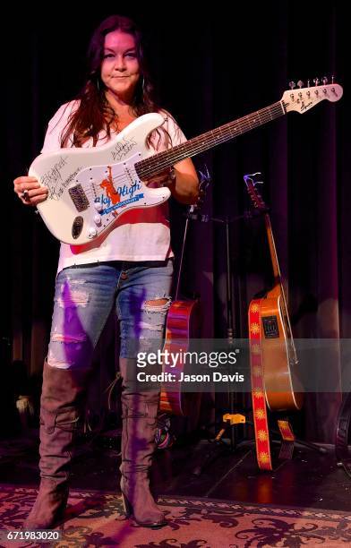 Recording Artist Gretchen Wilson signs a guitar to be auctioned during a private concert for Pediatric Cancer research on April 22, 2017 in...