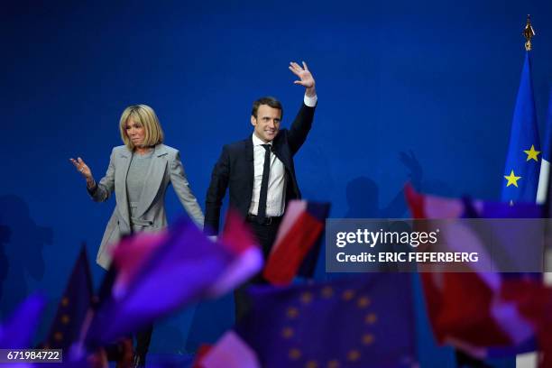 French presidential election candidate for the En Marche ! movement Emmanuel Macron and his wife Brigitte Trogneux arrive on stage at the Parc des...