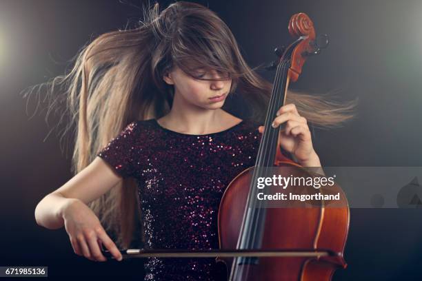 teenager-mädchen spielen cello leistung - wind instruments stock-fotos und bilder