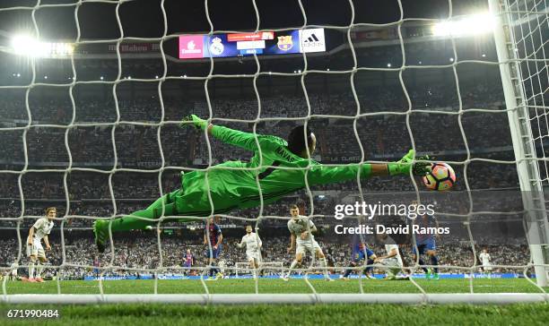 Keylor Navas of Real Madrid fails to stop Lionel Messi of Barcelona from scoring their third goal during the La Liga match between Real Madrid CF and...