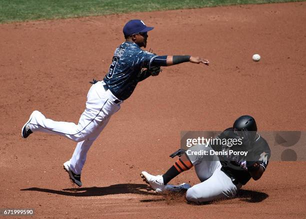 Erick Aybar of the San Diego Padres leaps over Marcell Ozuna of the Miami Marlins as he tries to turn a double play during the second inning of a...