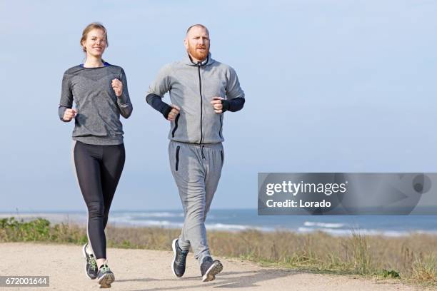 personal trainer and young female athlete working out near the sea - running netherlands stock pictures, royalty-free photos & images