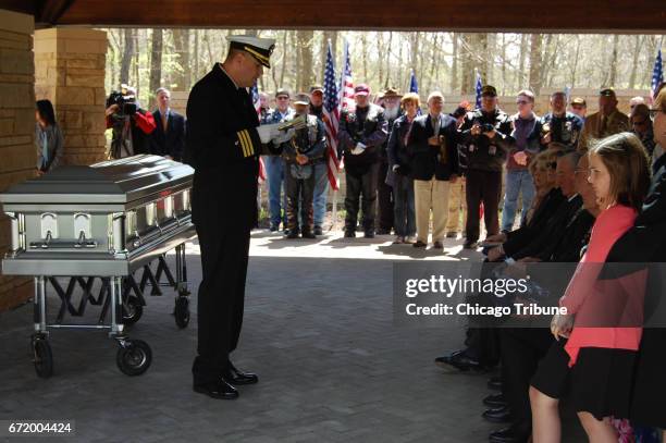 The Rev. Ron Neitzke reads from scripture and prays with the family of Joliet sailor Michael Galajdik during his burial on Saturday, April 22 at...