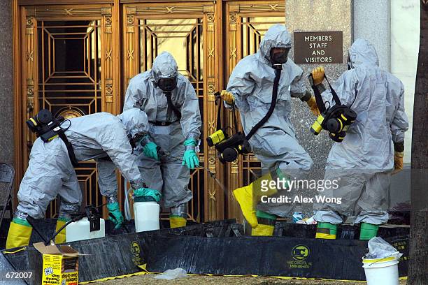 Hazardous material worker sprays his colleagues after they came out from an anthrax search at Dirksen Senate Office Building November 18, 2001 on...