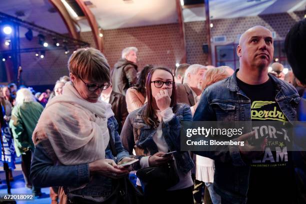 Attendees watch as results for the first round of the French presidential election are projected at a National Front party in Henin Beaumont, France,...