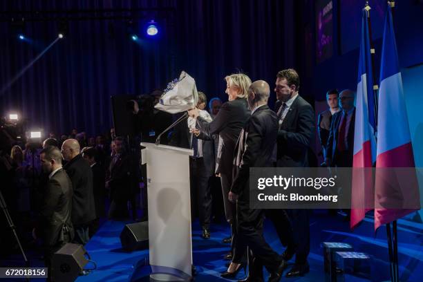 Marine Le Pen, leader of the French National Front and France's presidential candidate, center, receives flowers after speaking to attendees after...