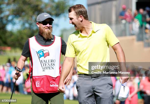 Kevin Chappell celebrates with his caddie Joe Greiner after putting in to win on the 18th green during the final round of the Valero Texas Open at...