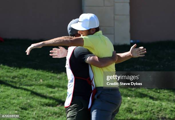 Kevin Chappell celebrates with his caddie Joe Greiner after putting in to win on the 18th green during the final round of the Valero Texas Open at...