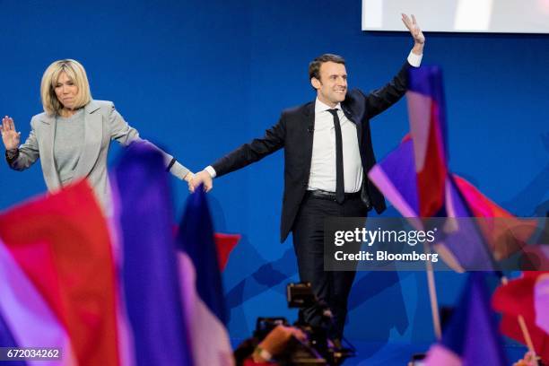 Emmanuel Macron, France's independent presidential candidate, and his wife Brigitte Trogneux wave as they arrive to deliver a speech after the first...