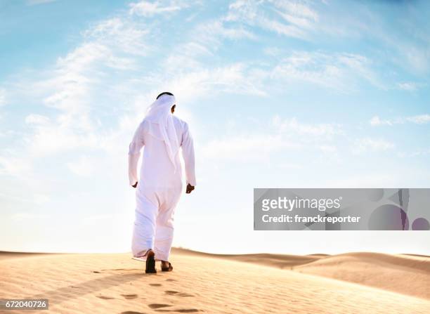 uomo arabo che prega nel deserto - qatar desert foto e immagini stock