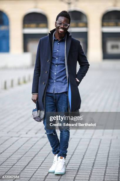 Sidya Sarr wears an Ice watch, Asos jewelry, an Asos shirt, a Zara jacket, a Bgarbo coat, a Nixon cap hat, Rayban glasses, Kevin Durant Nike shoes...