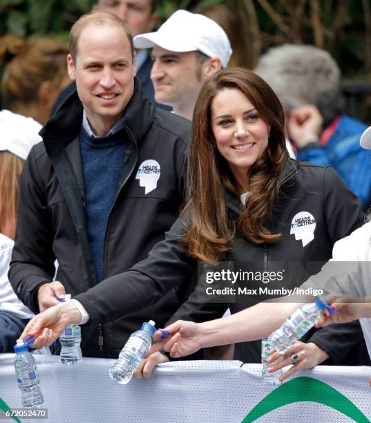 Prince William, Duke of Cambridge & Catherine, Duchess of Cambridge hand out water to runners taking part in the 2017 Virgin Money London Marathon on...