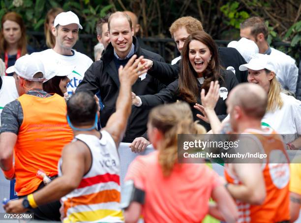 Prince William, Duke of Cambridge, Catherine, Duchess of Cambridge and Prince Harry hand out water to runners taking part in the 2017 Virgin Money...