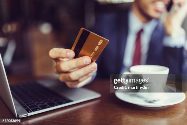 businessman in cafe using credit card for online shopping - debit card fraud stock pictures, royalty-free photos & images