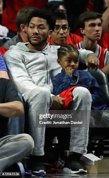 Former Chicago Bulls player Derrick Rose watches with son P.J. As the Bulls take on the Boston Celtics during Game Four of the Eastern Conference...