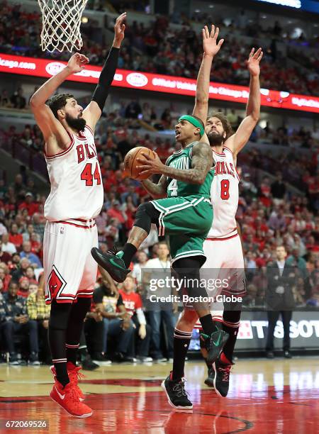 Boston Celtics' Isaiah Thomas scores a layup, splitting Chicago Bulls defenders Nikoal Mirotic and Robin Lopez during the third quarter. The Boston...