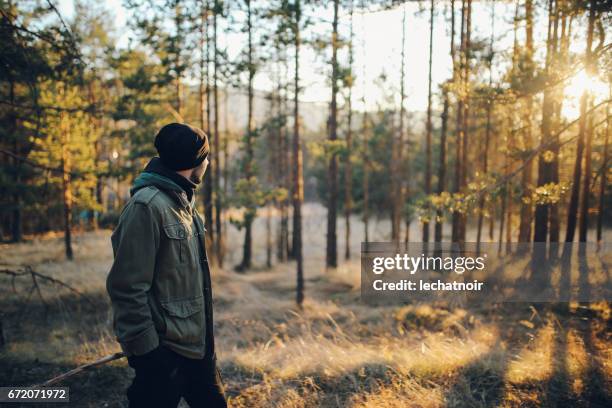 young man walking in the beautiful forest outdoors - parka stock pictures, royalty-free photos & images