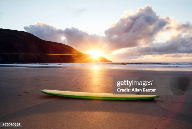 longboard surfboard resting on woolacombe beach - woolacombe beach devon stock pictures, royalty-free photos & images