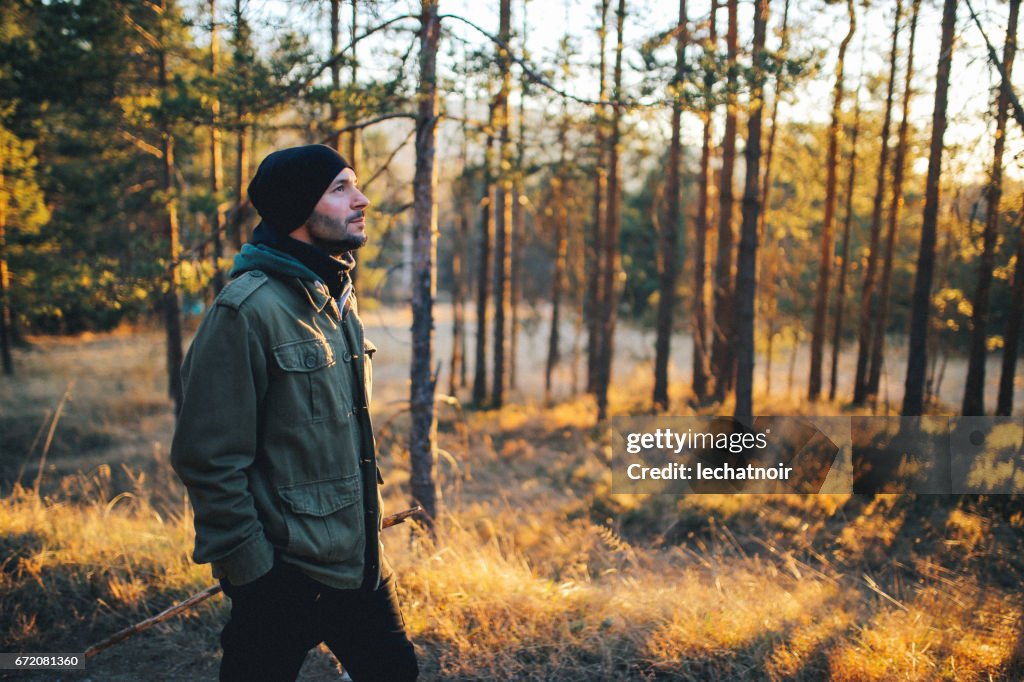 Young man walking in the beautiful forest outdoors