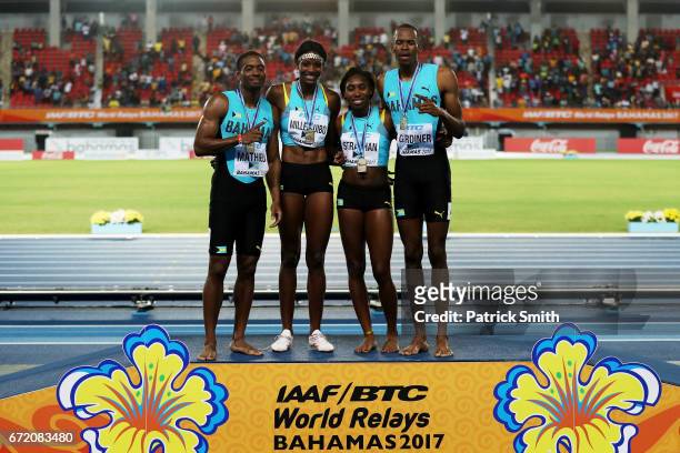 Steven Gardiner, Shaunae Miller-Uibo, Anthonique Strachan and Michael Mathieu of the Bahamas celebrate on the podium after placing first in the Mixed...