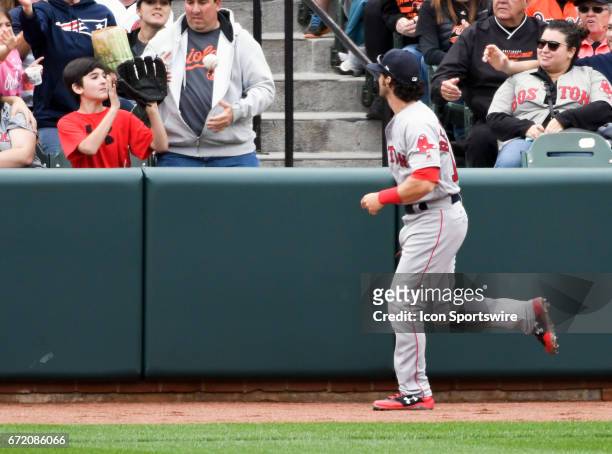 Boston Red Sox left fielder Andrew Benintendi tosses a ball to a young fan at the end of the sixth inning against the Baltimore Orioles on April 23,...