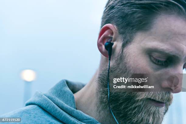 närbild på headsetet bärs av en man med skägg - street running bildbanksfoton och bilder