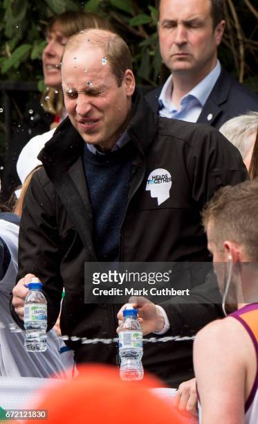 Prince William, Duke of Cambridge gets squirted with water at a water station during the 2017 Virgin Money London Marathon on April 23, 2017 in...