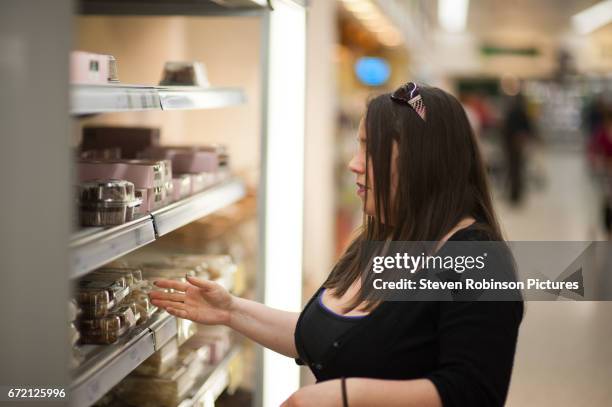 woman looking at cakes in supermarket - perth scotland fotografías e imágenes de stock