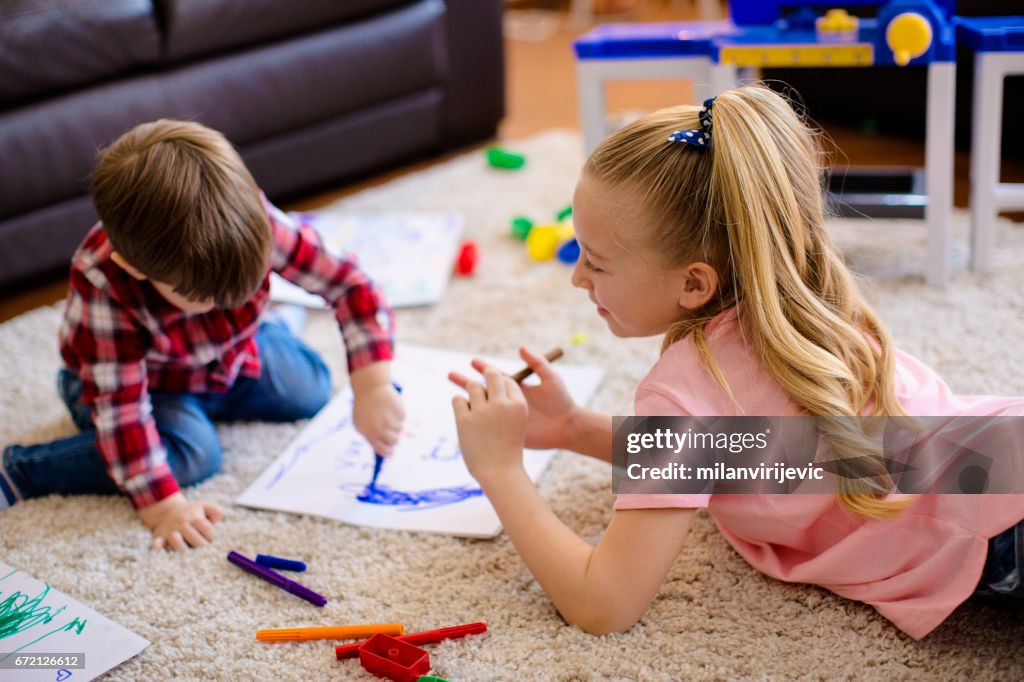 Kids painting together at the floor