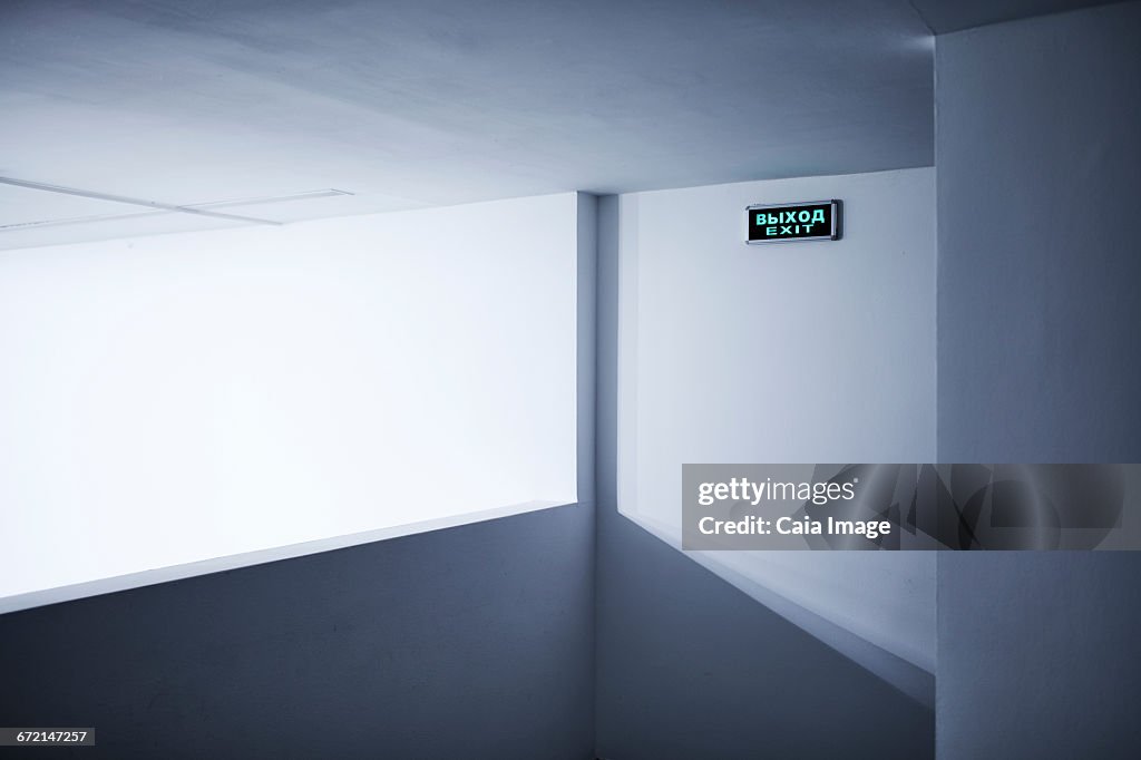 Neon exit sign on white wall