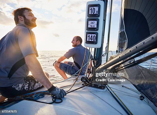 men monitoring wind on sailboat - boat gps stock-fotos und bilder