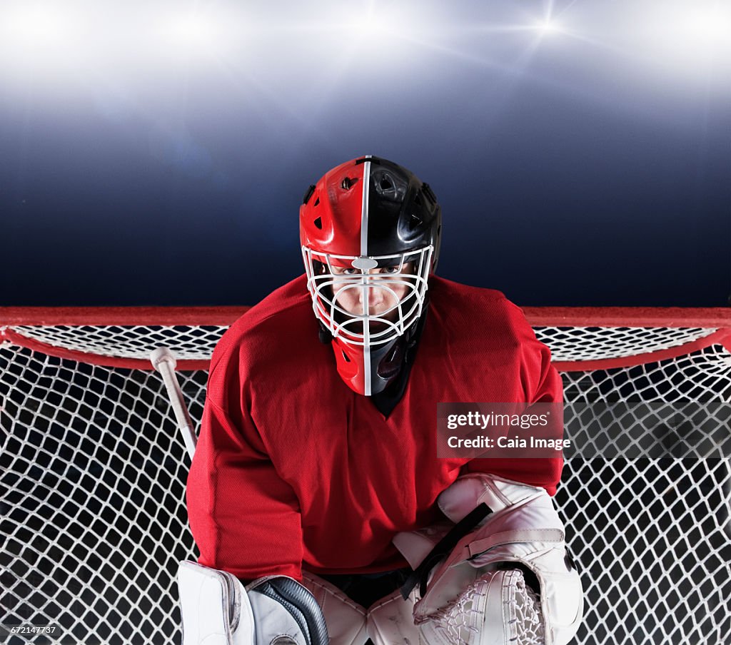 Portrait determined hockey goalie protecting goal net