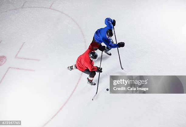 hockey players going for the puck on ice - hockey puck top view stock pictures, royalty-free photos & images