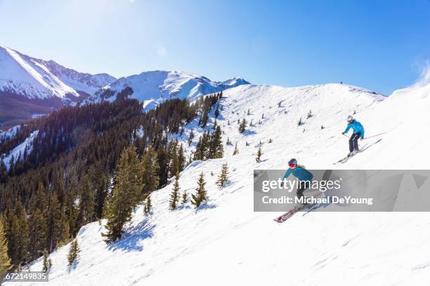 couple skiing on snowy mountain slope - taos stockfoto's en -beelden