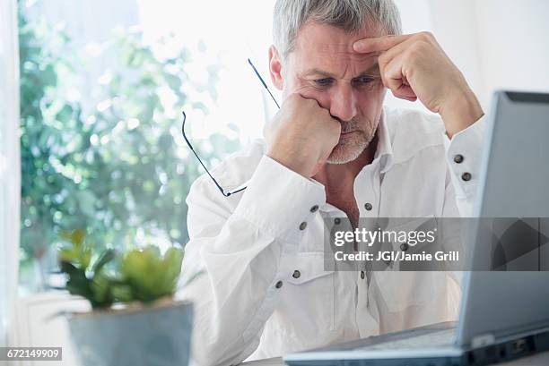 frustrated older caucasian man using laptop - concerned laptop stock pictures, royalty-free photos & images