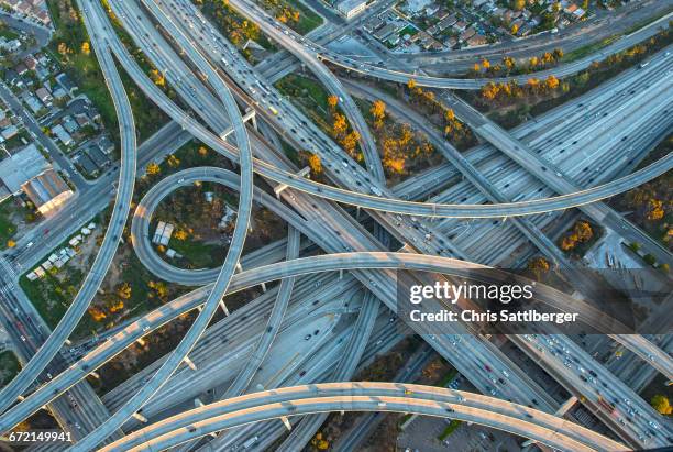 aerial view of highway interchange in cityscape - traffic aerial stock pictures, royalty-free photos & images