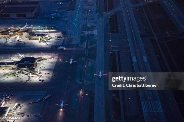 aerial view of airplanes taxing on airport runway - runway night stock pictures, royalty-free photos & images