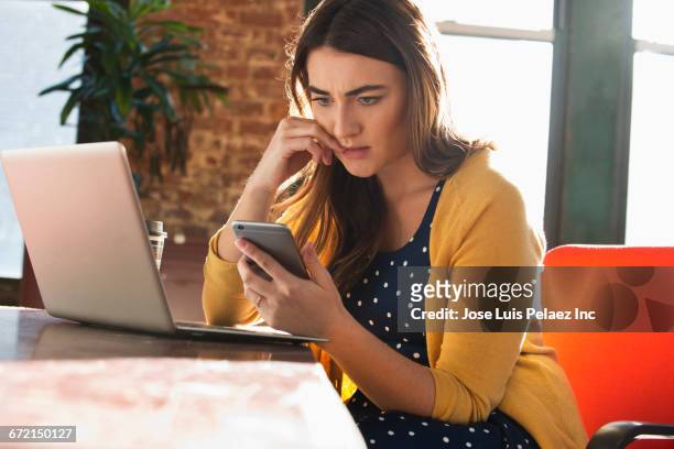 stressed caucasian businesswoman using cell phone - estrés fotografías e imágenes de stock