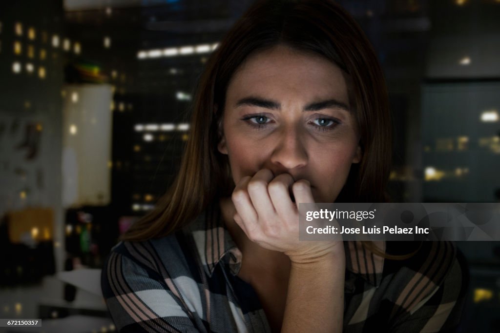 Worried Caucasian businesswoman with hand on chin