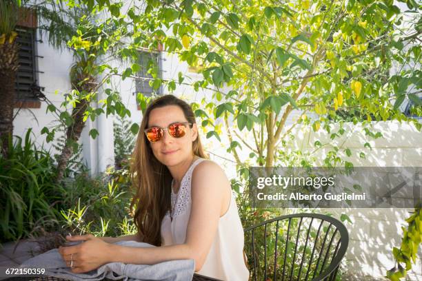 caucasian woman sitting at table in garden - alberto guglielmi imagens e fotografias de stock