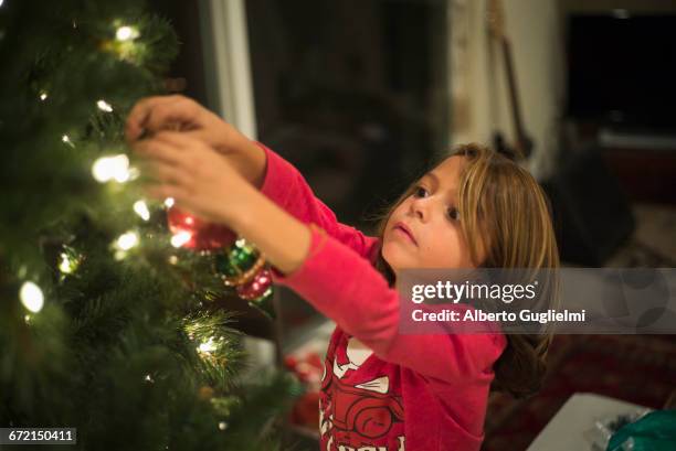 caucasian boy hanging ornament on christmas tree - alberto guglielmi imagens e fotografias de stock