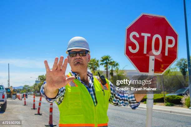 caucasian flagger gesturing stop with stop sign - traffic management stock pictures, royalty-free photos & images