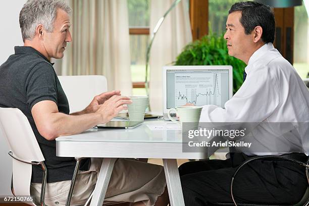man talking with financial advisor at table - witwer stock-fotos und bilder