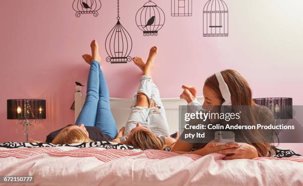 caucasian girl listening to music on cell phone watching friends - teen girl barefoot at home stock pictures, royalty-free photos & images