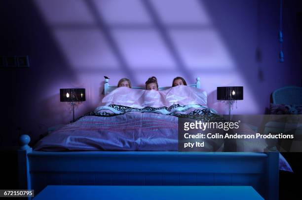 caucasian girls watching scary movie in bed at night - scary movie stockfoto's en -beelden