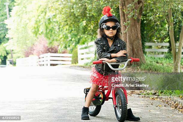 mixed race girl posing with attitude in leather jacket on bicycle - mädchen cool stock-fotos und bilder