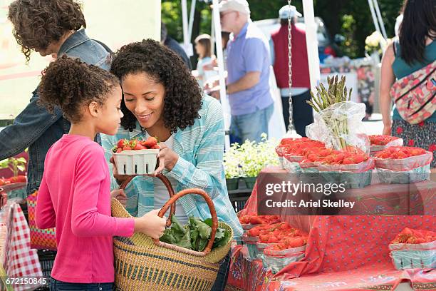 black mother and daughter smelling strawberries at farmers market - black market 個照片及圖片檔