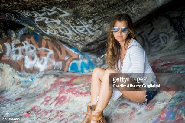 caucasian woman wearing american flag sunglasses on graffiti rocks - alberto guglielmi imagens e fotografias de stock