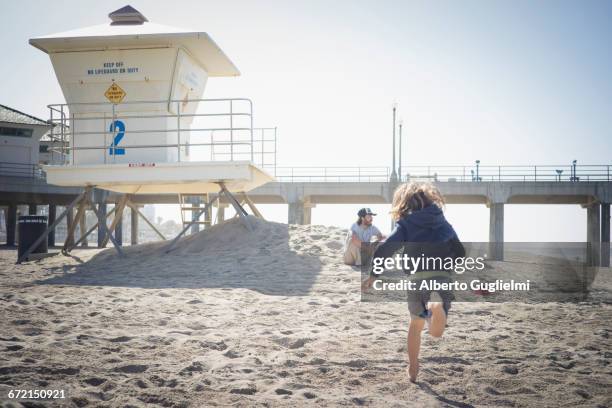 caucasian boy running to father on beach - alberto guglielmi stock pictures, royalty-free photos & images