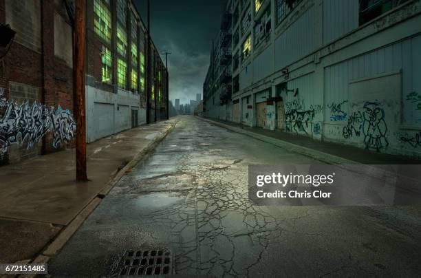 graffiti on walls on empty city street - alley fotografías e imágenes de stock